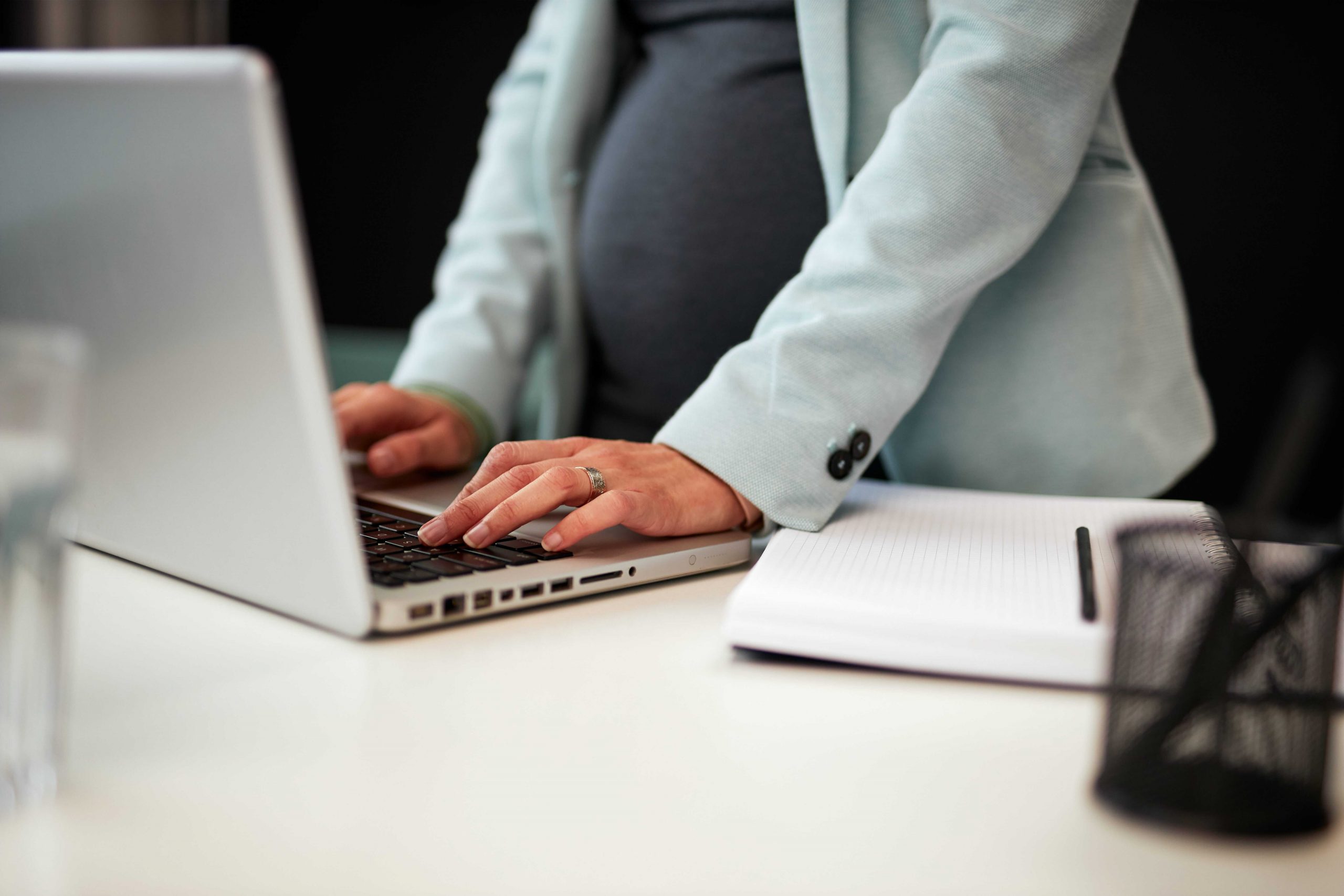 Pregnant woman working on a laptop from home