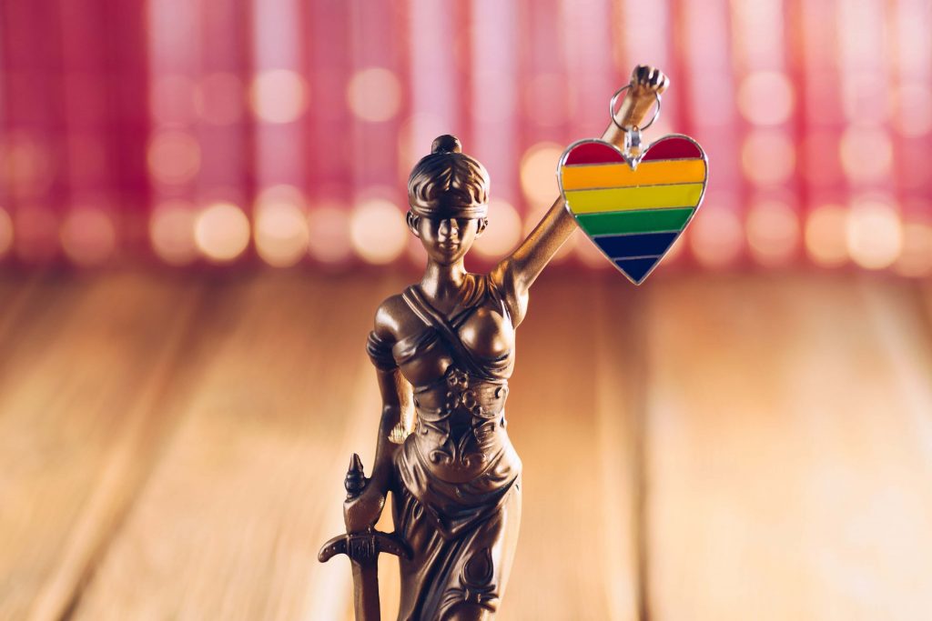 Bronze statue holding a heart with the LGBT pride flag colors